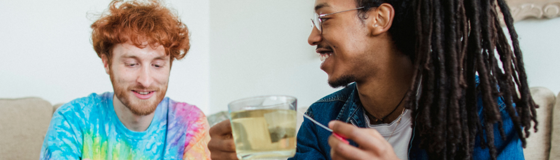 Photo of two young men talking and drinking tea