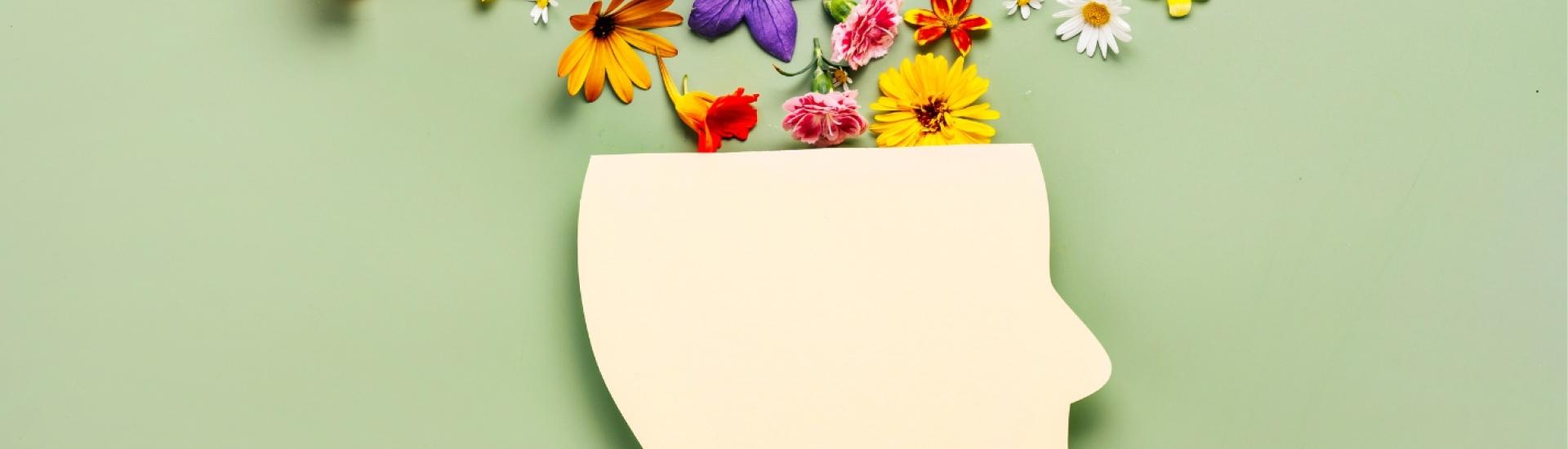 Paper icon of a head with flowers blooming out of the top