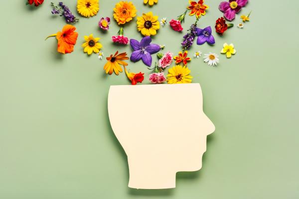 Paper icon of a head with flowers blooming out of the top