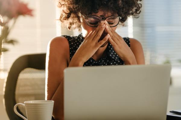 Lady with a stressed expression in front of a laptop